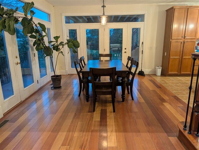 dining area with french doors and light hardwood / wood-style flooring