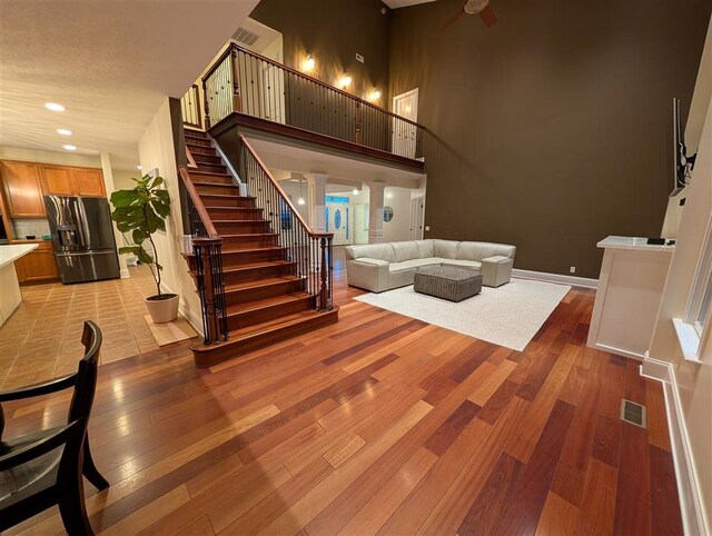 living room with a towering ceiling and light wood-type flooring