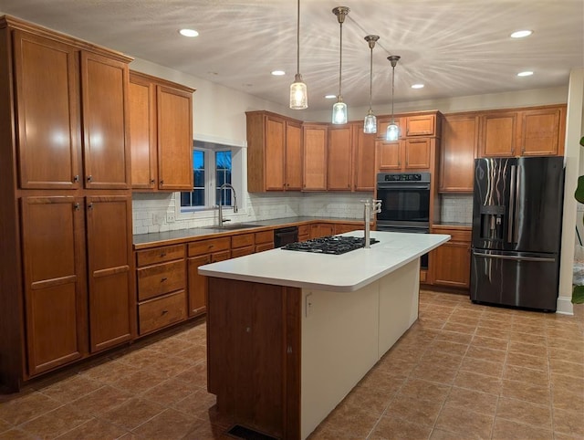 kitchen with sink, hanging light fixtures, black appliances, an island with sink, and a kitchen bar