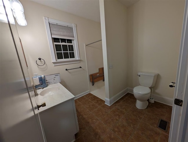 bathroom featuring vanity, washer / dryer, tile patterned floors, and toilet