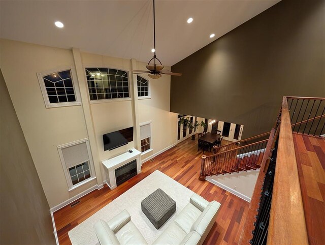 living room with hardwood / wood-style flooring and a towering ceiling