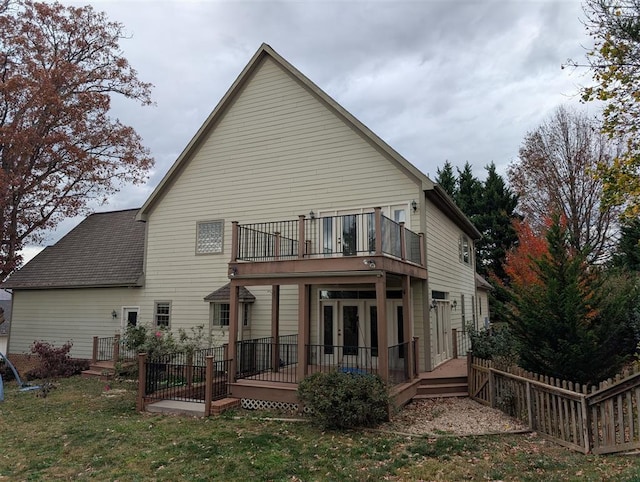 back of property with a wooden deck and a yard