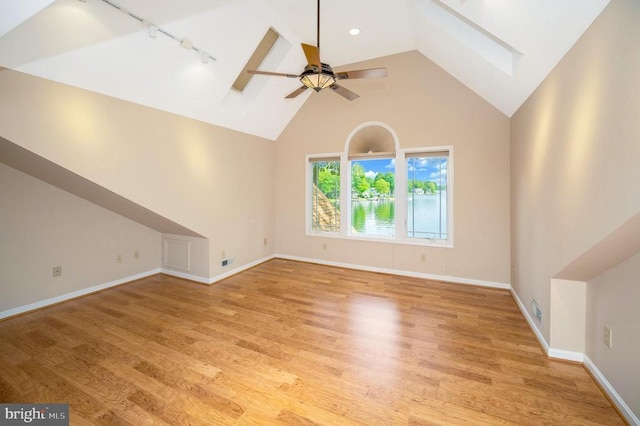 bonus room featuring ceiling fan, a skylight, visible vents, baseboards, and light wood finished floors