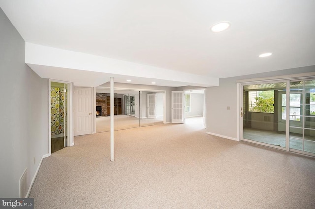 basement featuring a large fireplace, baseboards, carpet flooring, and recessed lighting