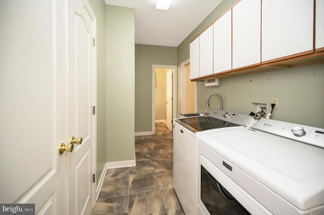 laundry area featuring washer and dryer, cabinet space, a sink, and baseboards