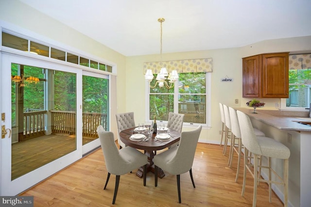 dining room featuring light wood-style floors, a chandelier, and baseboards