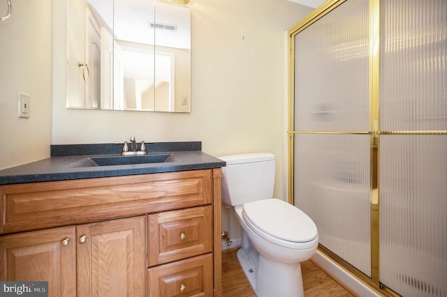 bathroom with toilet, a stall shower, vanity, and visible vents