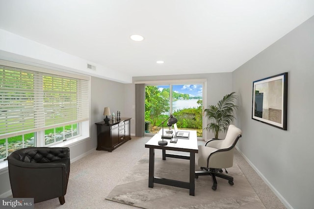 office space featuring visible vents, baseboards, and light colored carpet