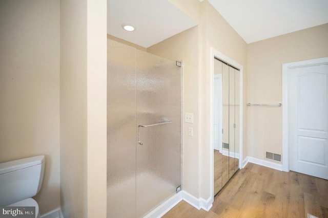 full bath featuring toilet, a stall shower, wood finished floors, and visible vents