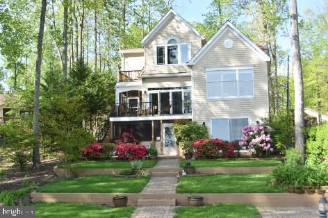 back of property featuring a yard and a balcony