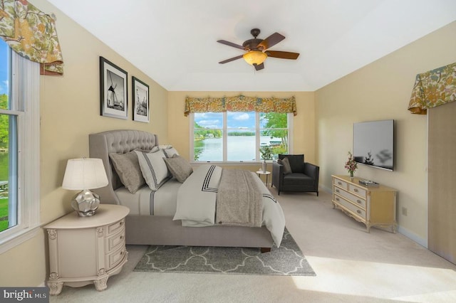 carpeted bedroom with ceiling fan, a tray ceiling, and baseboards