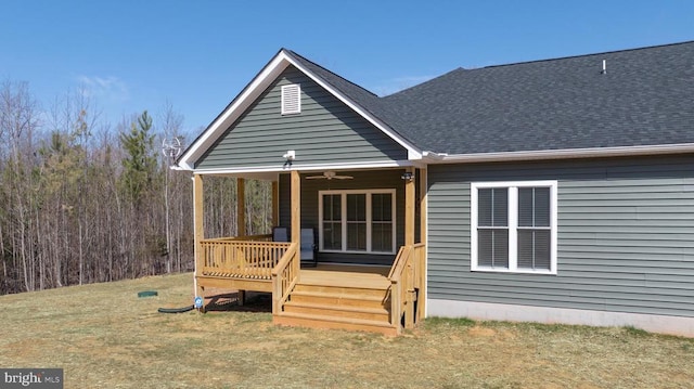 back of house with a ceiling fan and roof with shingles