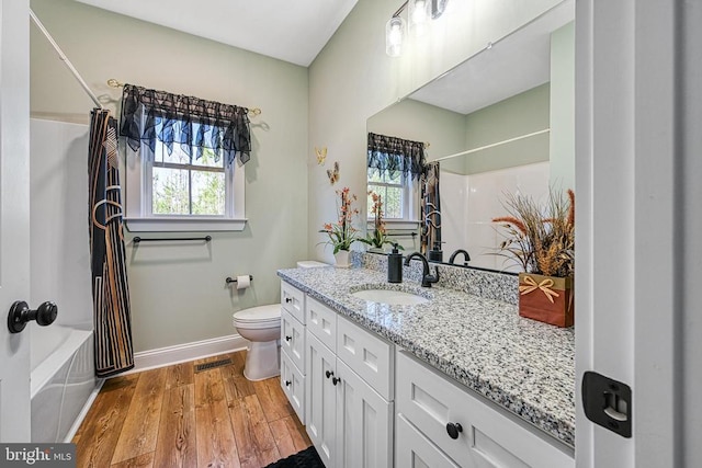 bathroom featuring visible vents, plenty of natural light, toilet, and wood finished floors