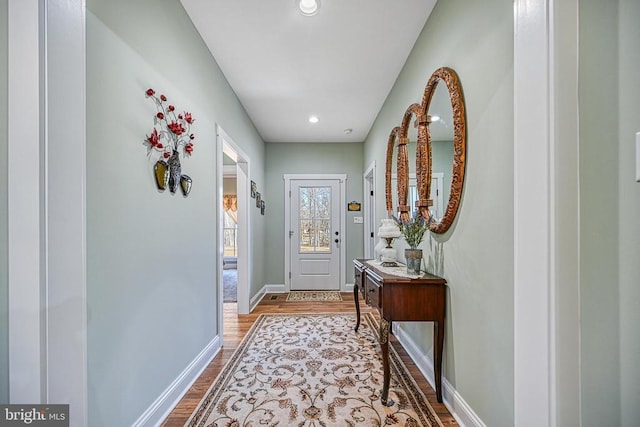 doorway to outside with recessed lighting, wood finished floors, and baseboards