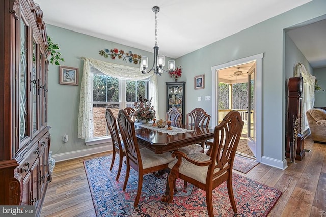 dining area with an inviting chandelier, light wood-style flooring, and baseboards