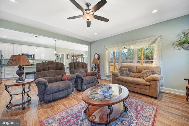 living area with recessed lighting, a ceiling fan, baseboards, and light wood finished floors