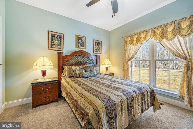 carpeted bedroom featuring baseboards and ceiling fan