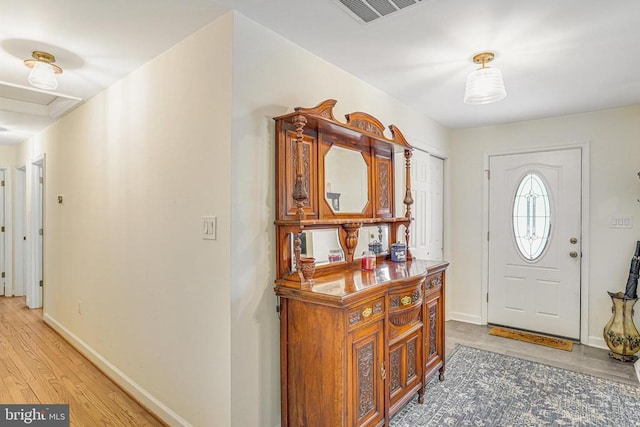 foyer featuring visible vents, light wood-style flooring, and baseboards