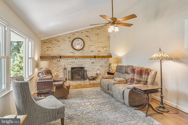 living room with baseboards, a ceiling fan, lofted ceiling, wood finished floors, and a brick fireplace