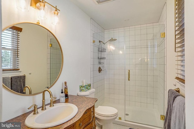 bathroom featuring toilet, a shower stall, visible vents, and vanity