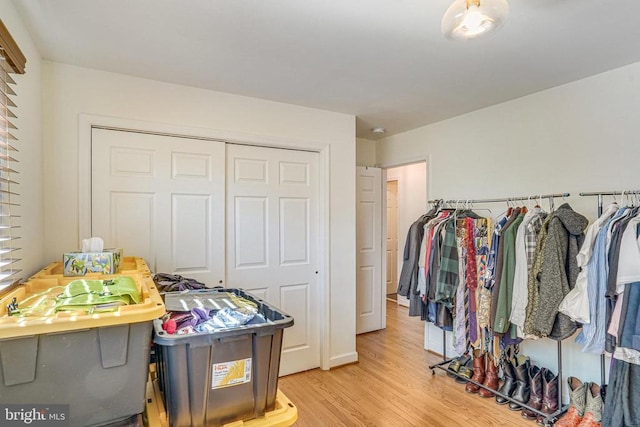 walk in closet with light wood-style flooring