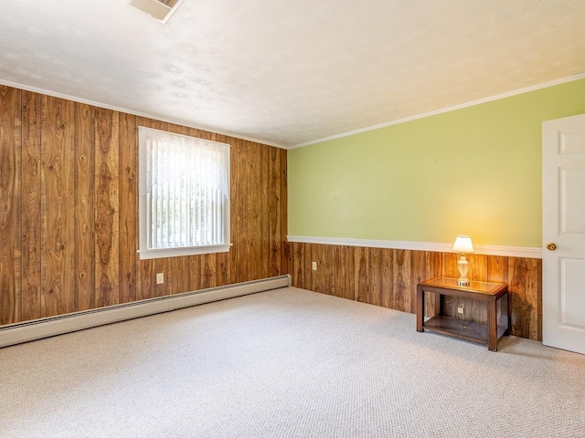 carpeted spare room with crown molding, a baseboard radiator, a textured ceiling, and wood walls