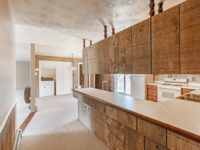 kitchen with washer / dryer, sink, light colored carpet, baseboard heating, and white appliances