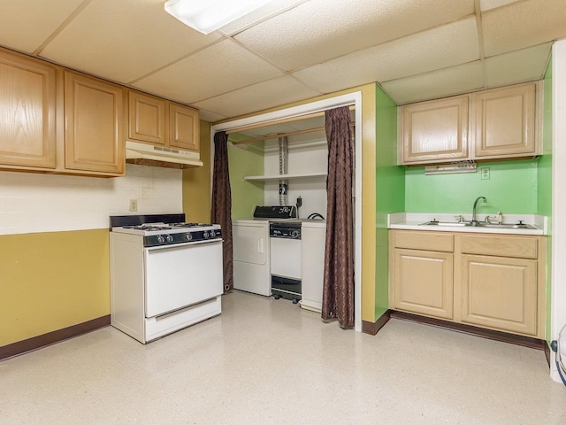 kitchen with sink, white range with gas stovetop, tasteful backsplash, washing machine and dryer, and a drop ceiling