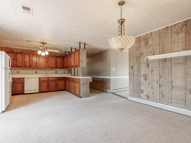 kitchen featuring sink, hanging light fixtures, baseboard heating, light carpet, and white appliances