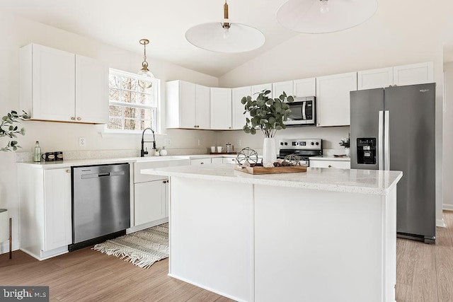 kitchen featuring lofted ceiling, light wood-style flooring, appliances with stainless steel finishes, and a sink