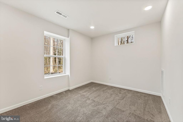 empty room featuring visible vents, recessed lighting, baseboards, and carpet floors