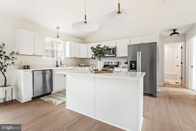 kitchen featuring white cabinetry, a kitchen island, light wood-type flooring, and stainless steel appliances