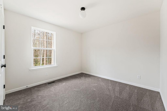 spare room with carpet, visible vents, and baseboards