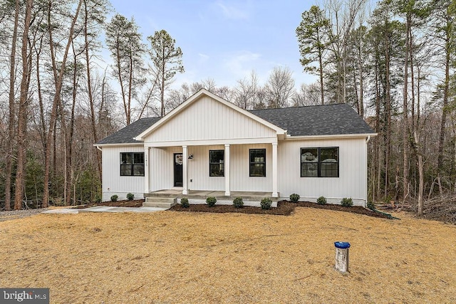 modern inspired farmhouse with covered porch and a shingled roof