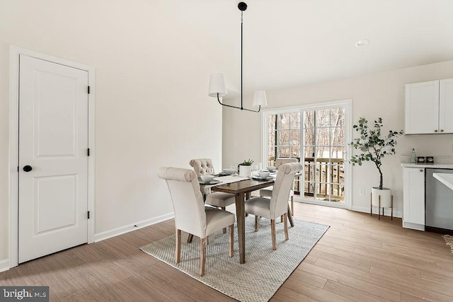 dining area with baseboards and light wood finished floors