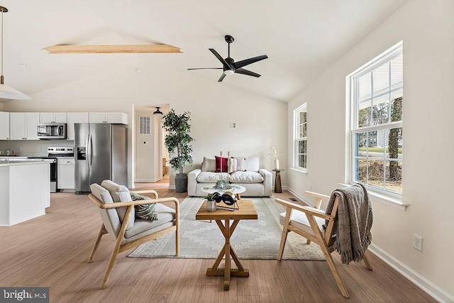 living area with light wood-style flooring, baseboards, high vaulted ceiling, and ceiling fan