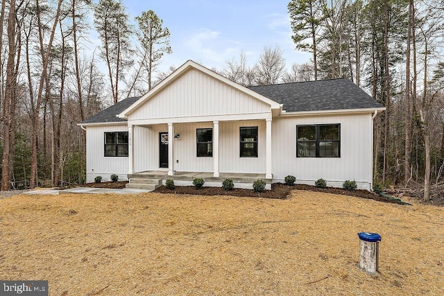 modern inspired farmhouse with a porch and a shingled roof