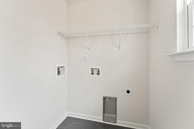 laundry room with baseboards, laundry area, hookup for a washing machine, electric dryer hookup, and dark tile patterned flooring