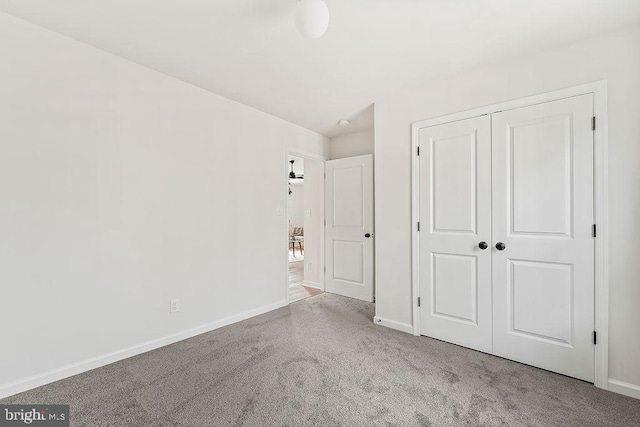 unfurnished bedroom with a closet, baseboards, and carpet floors