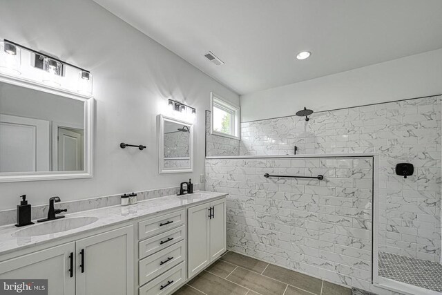 bathroom featuring vanity and tiled shower