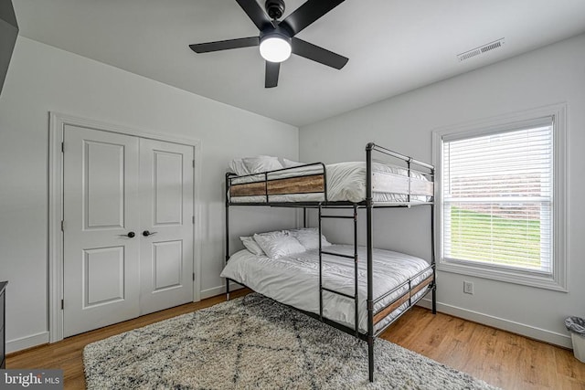 bedroom featuring hardwood / wood-style flooring, ceiling fan, and a closet