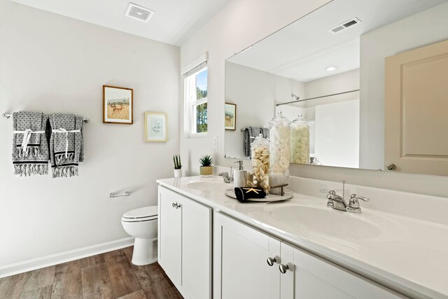 bathroom with vanity, wood-type flooring, toilet, and walk in shower