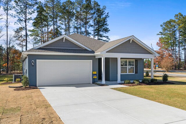 view of front facade featuring a garage, central AC, a porch, and a front yard