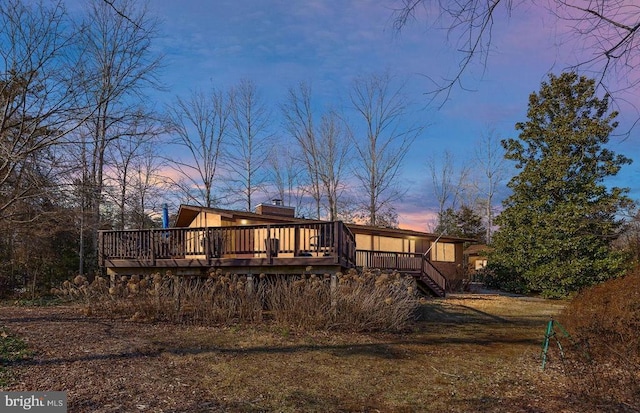 back house at dusk with a deck