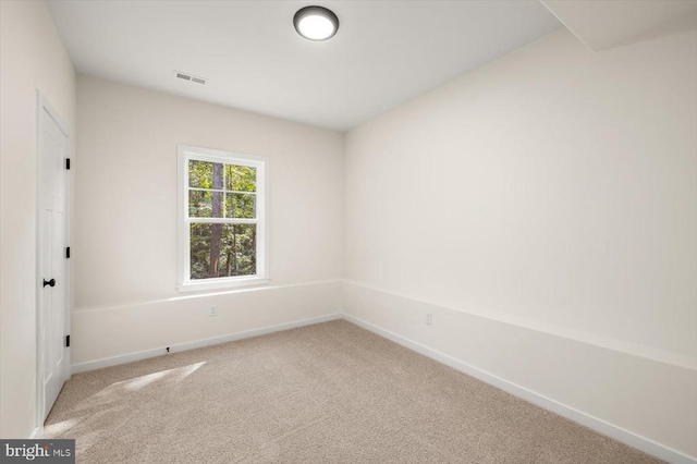 unfurnished room with baseboards, visible vents, and light colored carpet