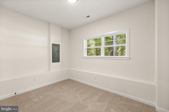 carpeted empty room featuring electric panel, visible vents, and baseboards