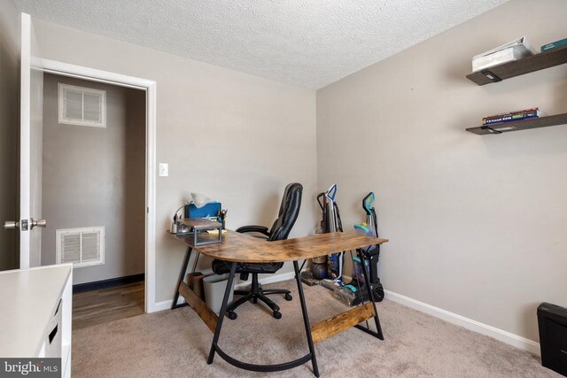 home office with baseboards, visible vents, and light colored carpet