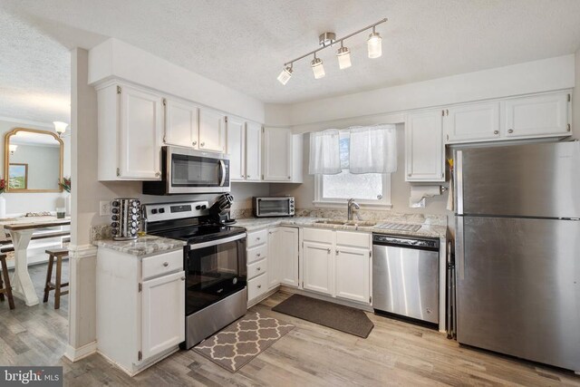 kitchen featuring white cabinets, stainless steel appliances, and a sink