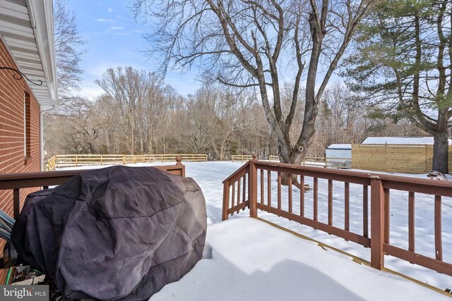 snow covered deck featuring fence and grilling area