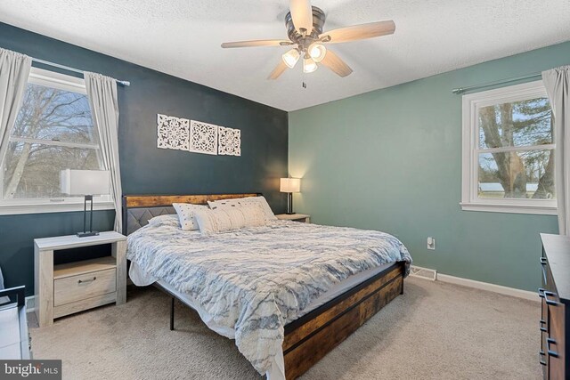 bedroom with carpet floors, multiple windows, visible vents, and baseboards